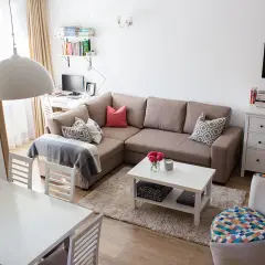 Przytulny salon z narożnikiem, stołem i biurkiem. Układ mieszkań w bloku z wielkiej płyty zaaranżowany na nowo.