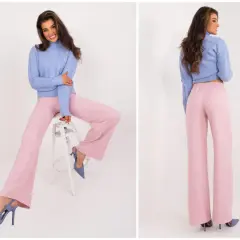 Modelka w swetrze i szerokich spodniach w kolorze brudny róż. Elegancka stylizacja na co dzień.