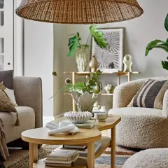 Przytulny salon styl skandynawski z beżową kanapą, puszystym fotelem i drewnianym stolikiem kawowym.
